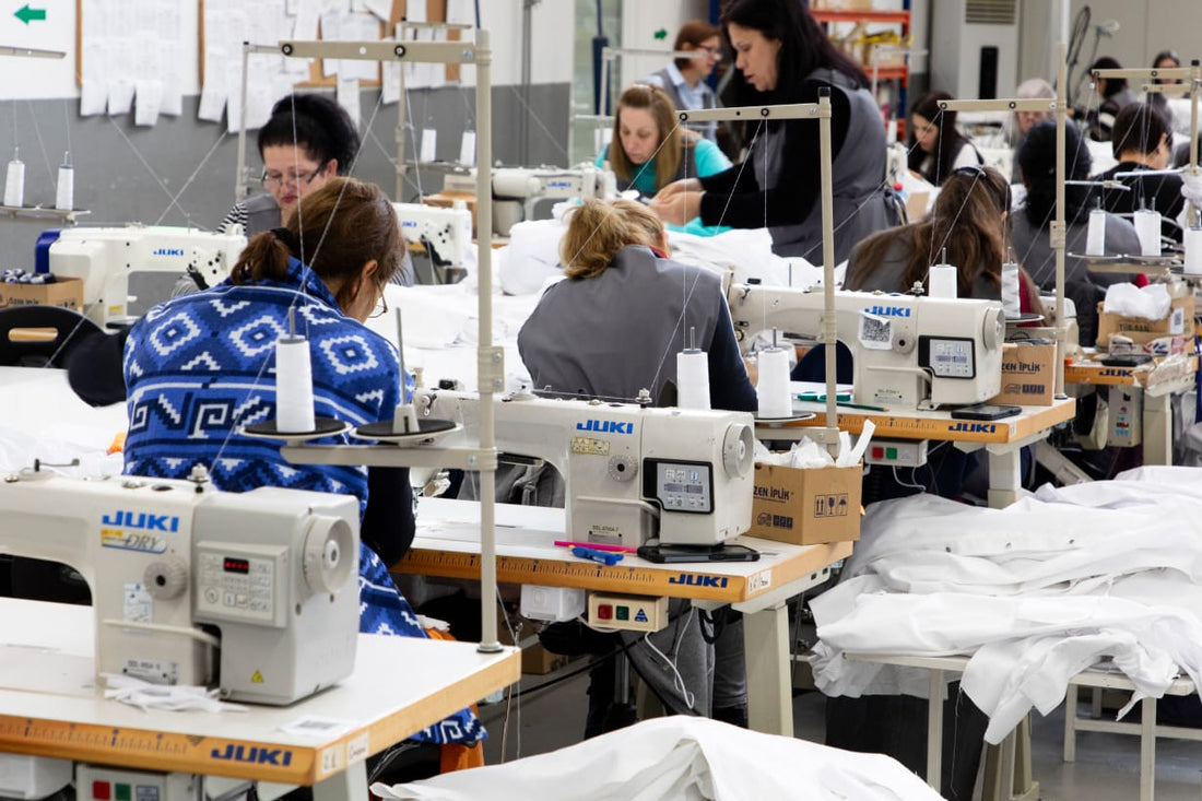 Naaiatelier met industriele naaimachines en witte kokskleding