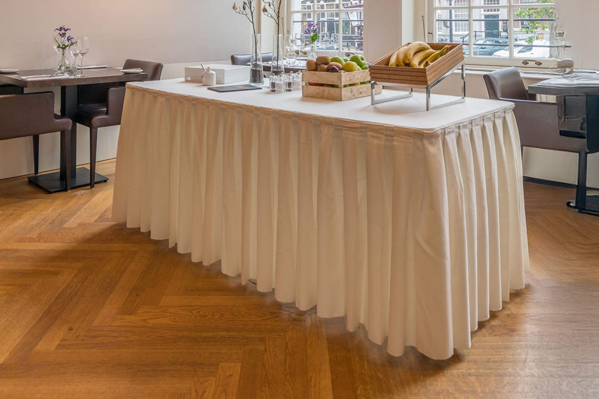 Cremekleurige tafelrok met boxplooi aan een buffettafel in een ontbijtzaal
